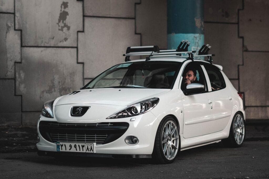 Citadine Peugeot blanche, trois quarts avant